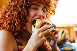 Kobieta jedząca Burger Drwala