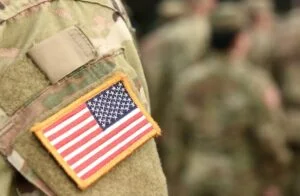 Flaga USA na mundurze żołnierza, symbol tego, że wojska amerykańskie w Polsce stacjonują na stałe i rotacyjnie.